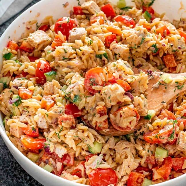 freshly made chicken orzo pasta salad in a white bowl.