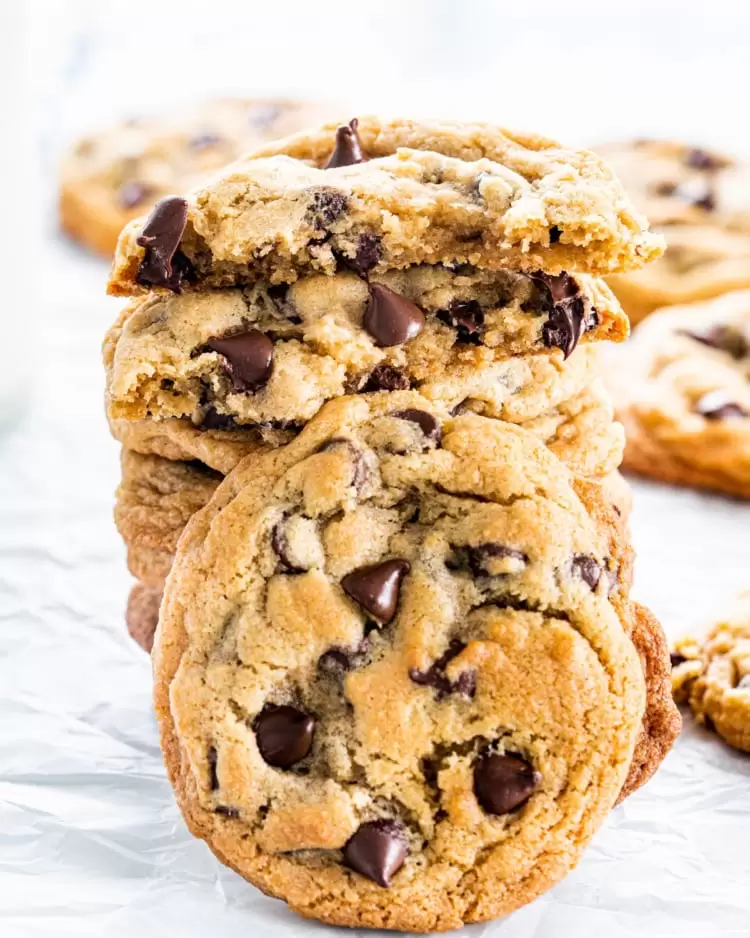 a stack of chocolate chip cookie with one cookie broken in half