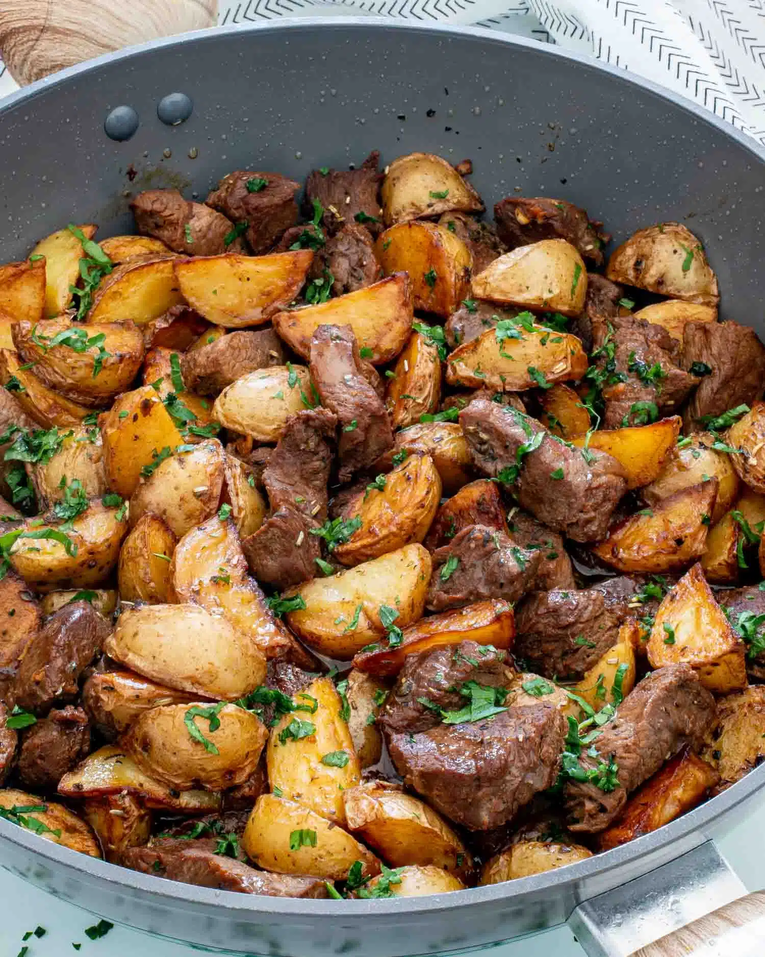 freshly made garlic butter steak and potatoes in a skillet.