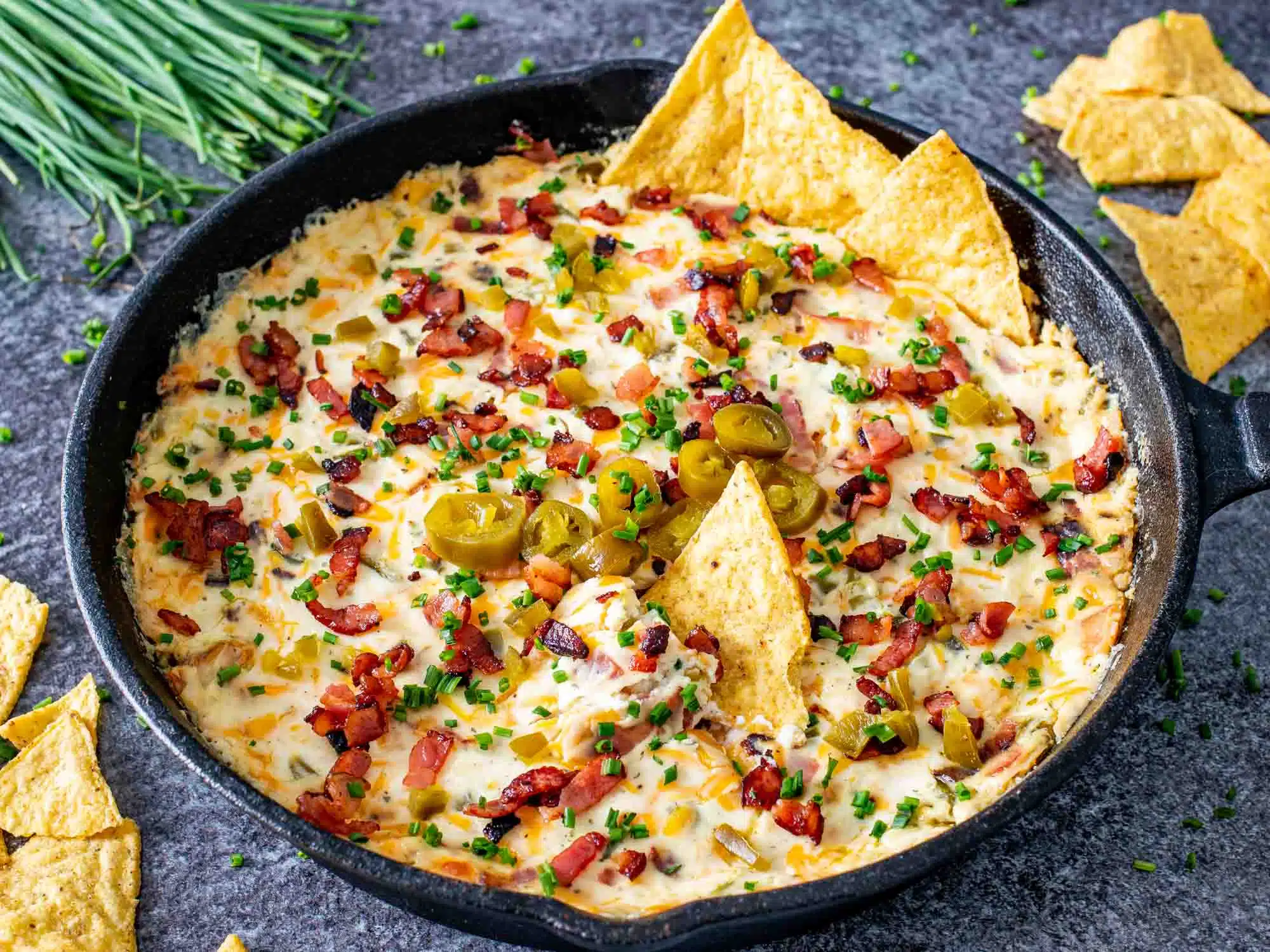 jalapeno popper dip in a black cast iron skillet fresh out of the oven.