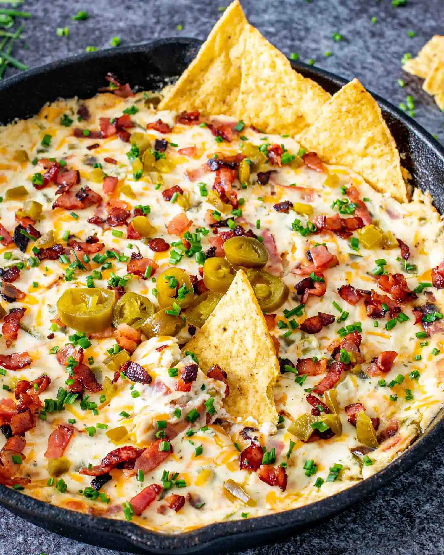 jalapeno popper dip in a black cast iron skillet fresh out of the oven.