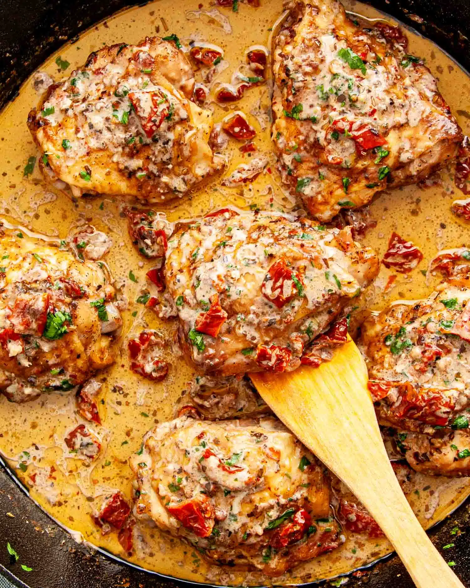 freshly made marry me chicken in a cast iron skillet garnished with parsley.