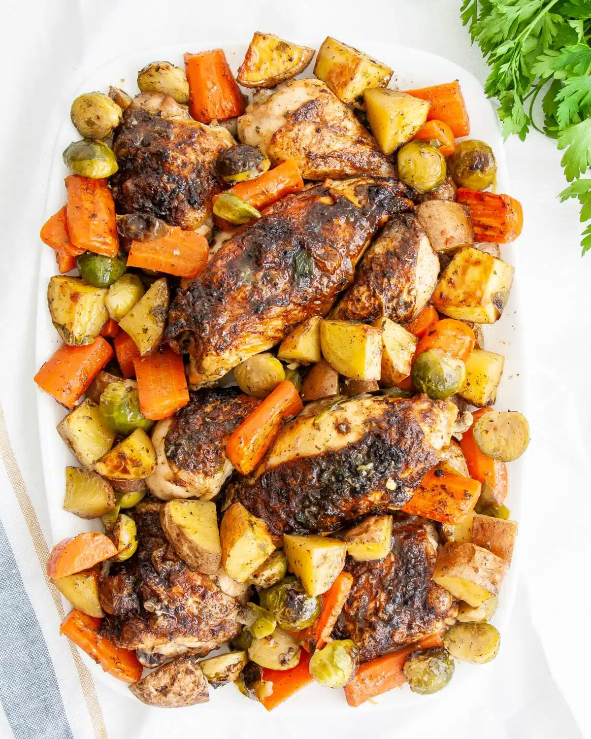 overhead shot of roasted chicken and vegetables on a white platter